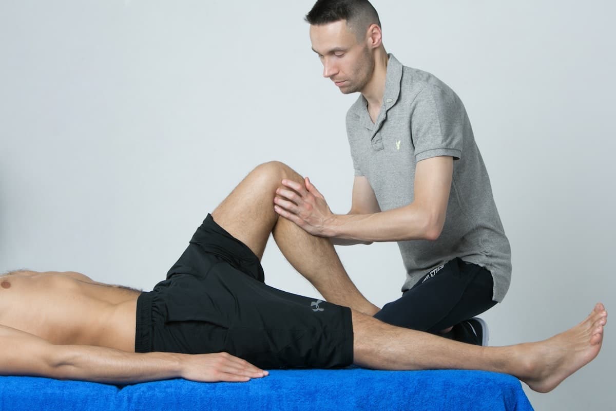Physiotherapist treating a patient's knee on a clinic treatment table