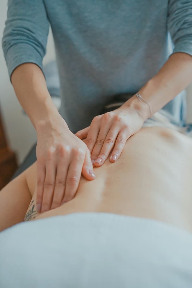 Physiotherapist giving hands-on back treatment to a patient at home